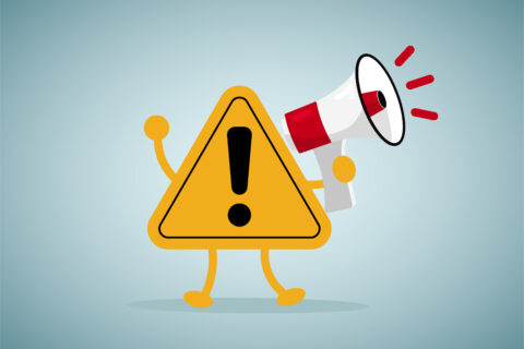 Un panneau de signalisation de danger, point d'exclamation sur fond jaune. Le panneau a des bras et des jambes et tient un mégaphone